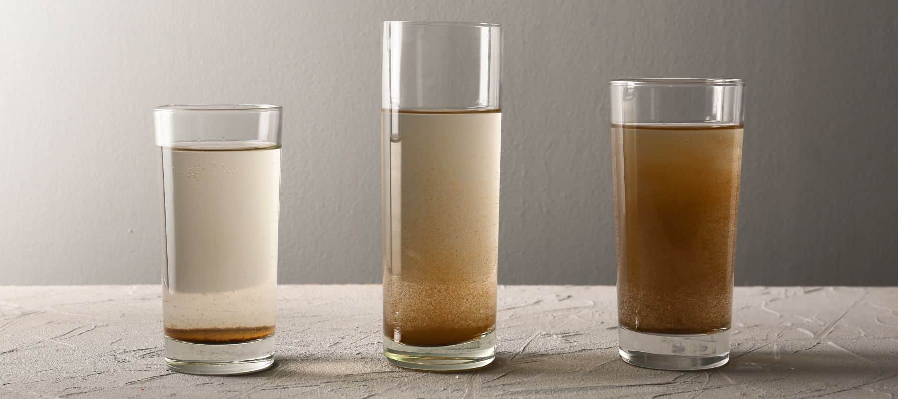 three glass cups of different kinds of dirty water